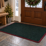 Holiday entry mat in Hedge Green carpet with burgundy binding inside a front door